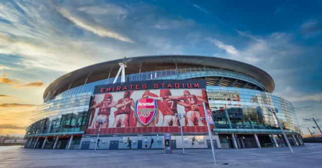 View of Emirates Stadium, home of Arsenal FC in London, showcasing modern architecture under a vibrant sky.