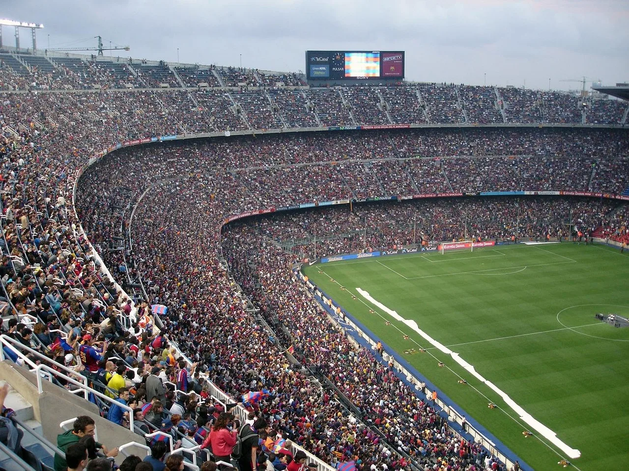 A wide view of a professional football stadium pitch during the day.