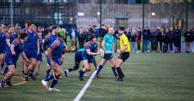 Vibrant rugby game with teams competing on a field in Manchester, England.