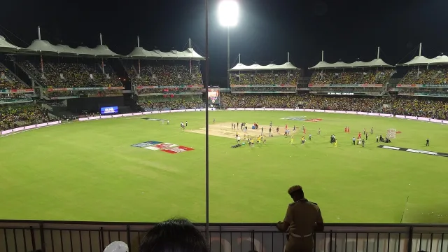 A professional cricket pitch at a large stadium during a match.