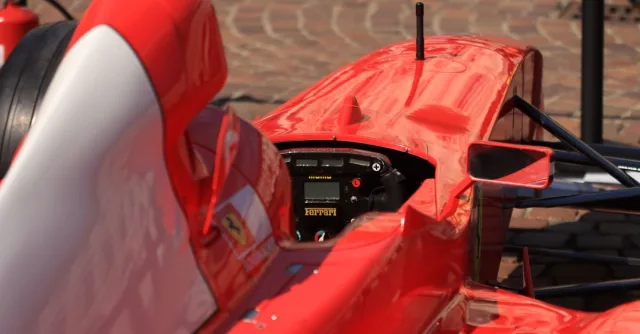 Detailed view of a red racing car's cockpit, highlighting its sleek design and controls.