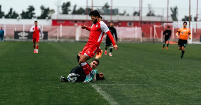 Action-packed soccer match featuring a dynamic tackle on the field.