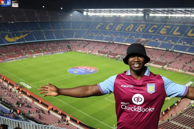 A wide view of a professional football stadium pitch under stadium lights.
