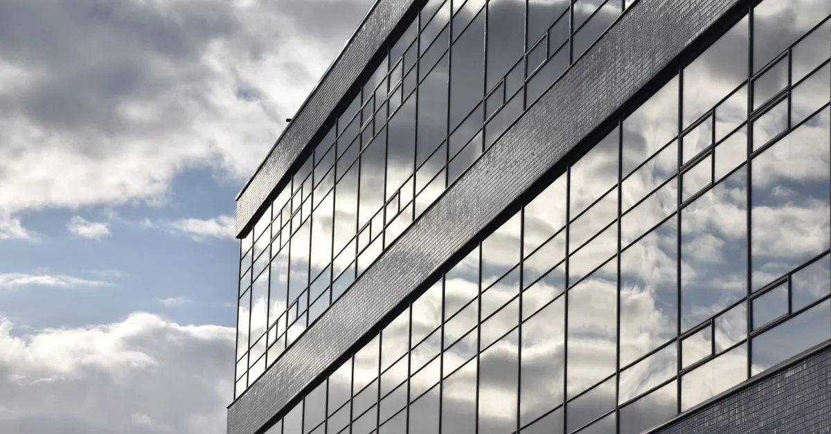 Clouds reflecting on a sleek office building facade in Amsterdam. Urban architecture.