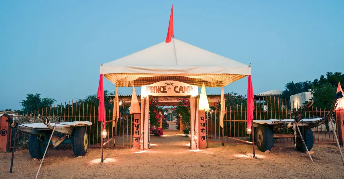 Scenic entrance of Prince Desert Camp with traditional carts in Jaisalmer, India during twilight.