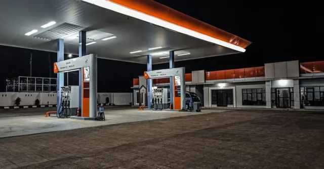 A contemporary gas station illuminated at night, highlighting pump stations and canopy.