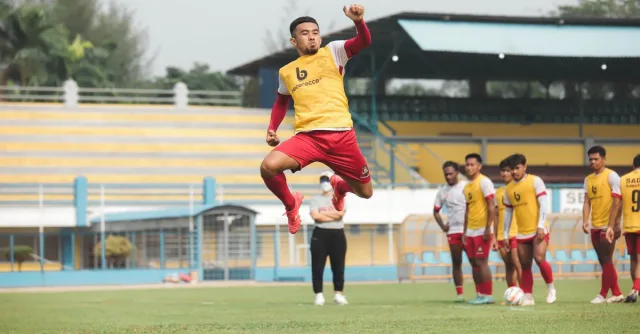 Soccer players practice on a vibrant field in Jakarta, showcasing athleticism and teamwork.