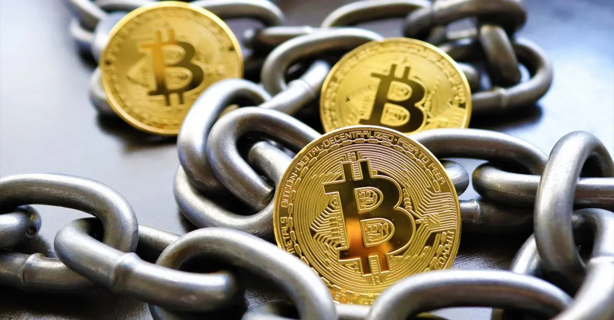 Close-up of Bitcoin coins entwined in metallic chains showcasing cryptocurrency security.