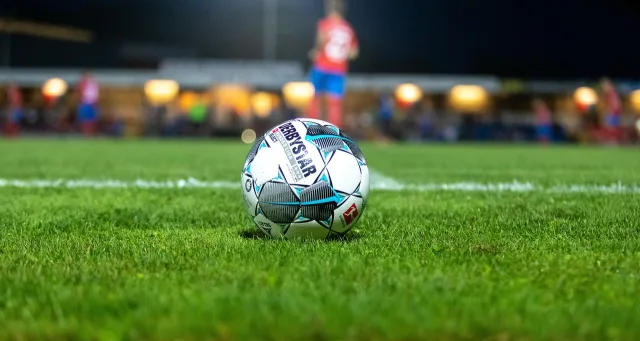 A professional football stadium lit up at night under a dark sky.