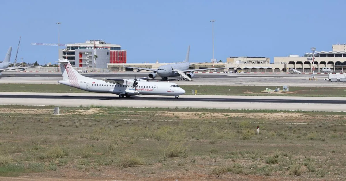 A commercial airplane preparing for takeoff on a sunny day at the airport.