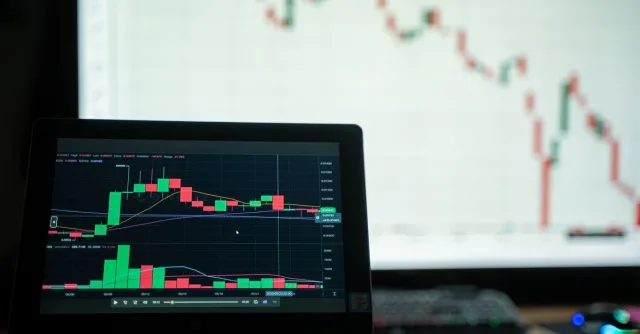 Close-up of a laptop showing cryptocurrency market charts in a trading environment.