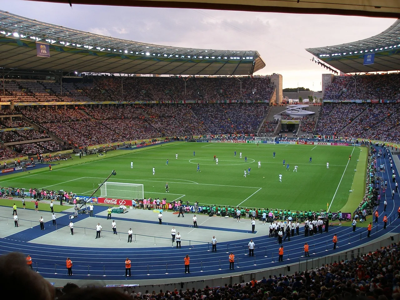 A wide shot of a professional football stadium during a match at night.