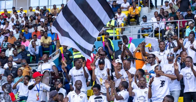 Lively crowd of sports fans cheering at a football match, showcasing Rwandan team spirit.
