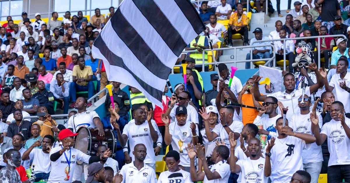 Lively crowd of sports fans cheering at a football match, showcasing Rwandan team spirit.