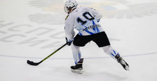 Ice hockey player wearing jersey number 10 skating on an ice rink during a game.