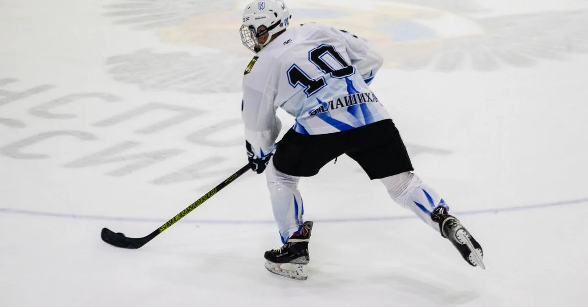 Ice hockey player wearing jersey number 10 skating on an ice rink during a game.