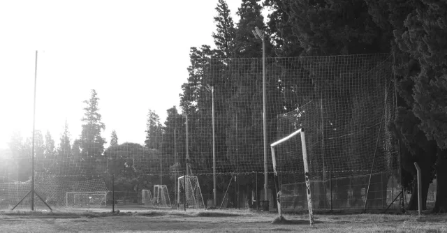 Black and white photo of a rustic football field in Córdoba, Argentina at sunrise.