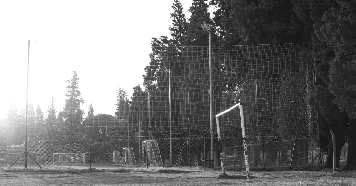 Black and white photo of a rustic football field in Córdoba, Argentina at sunrise.