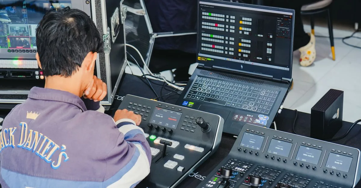 Tech professional working with video production equipment. Monitors and control panels in use.