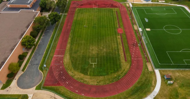 Aerial view of track and soccer field in Menomonie, WI, showcasing sports facilities from above.