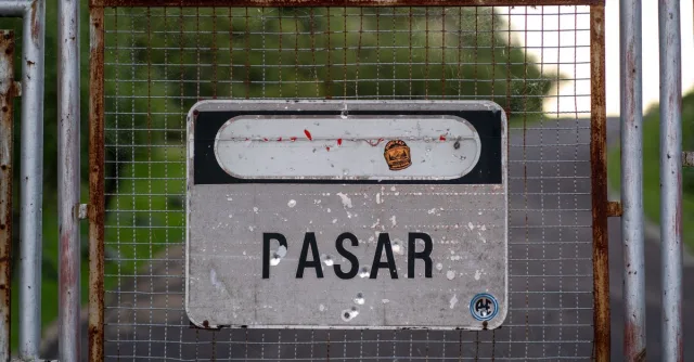 Weathered no entry sign on a rusty gate in Córdoba, Argentina, conveying restriction.