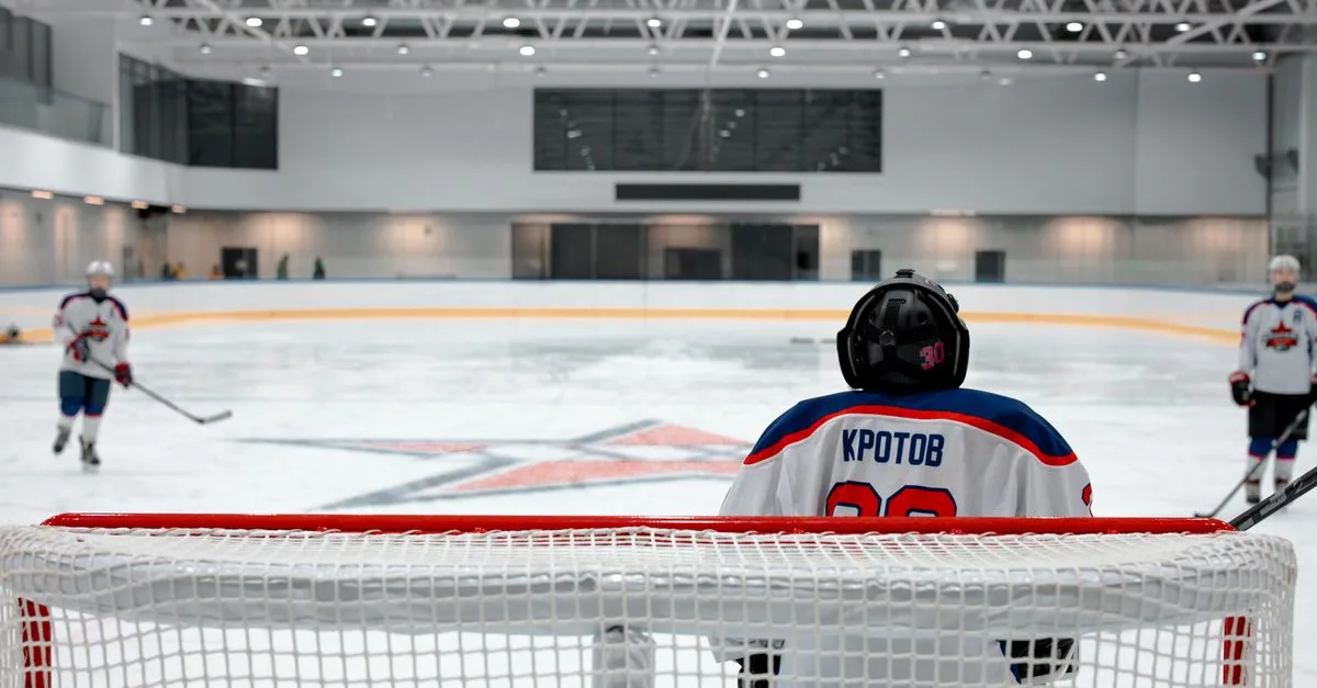Ice hockey game with a focused goalie defending the goal, showcasing skill and teamwork indoors.