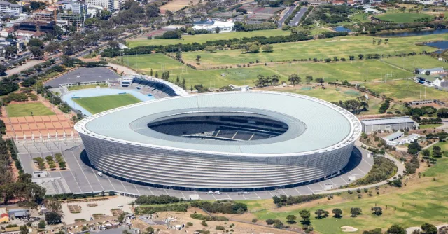 A stunning aerial shot showcasing the iconic Cape Town Stadium surrounded by the urban landscape and greenery.
