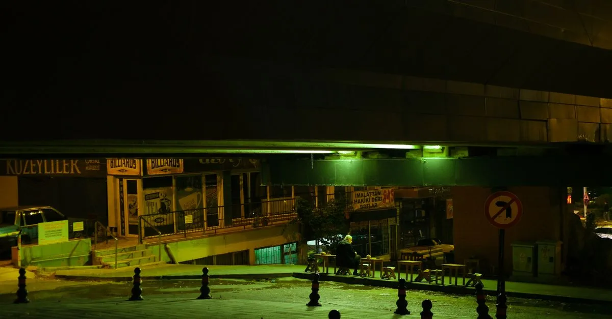 Moody urban nighttime scene with underpass in Turkey, illuminated by green light.