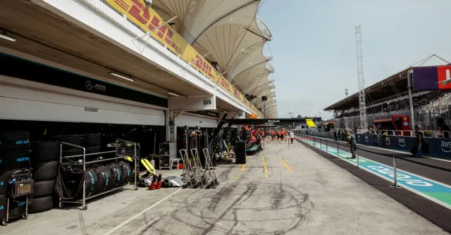 View of a Formula 1 pit lane with garage preparations and racing equipment.