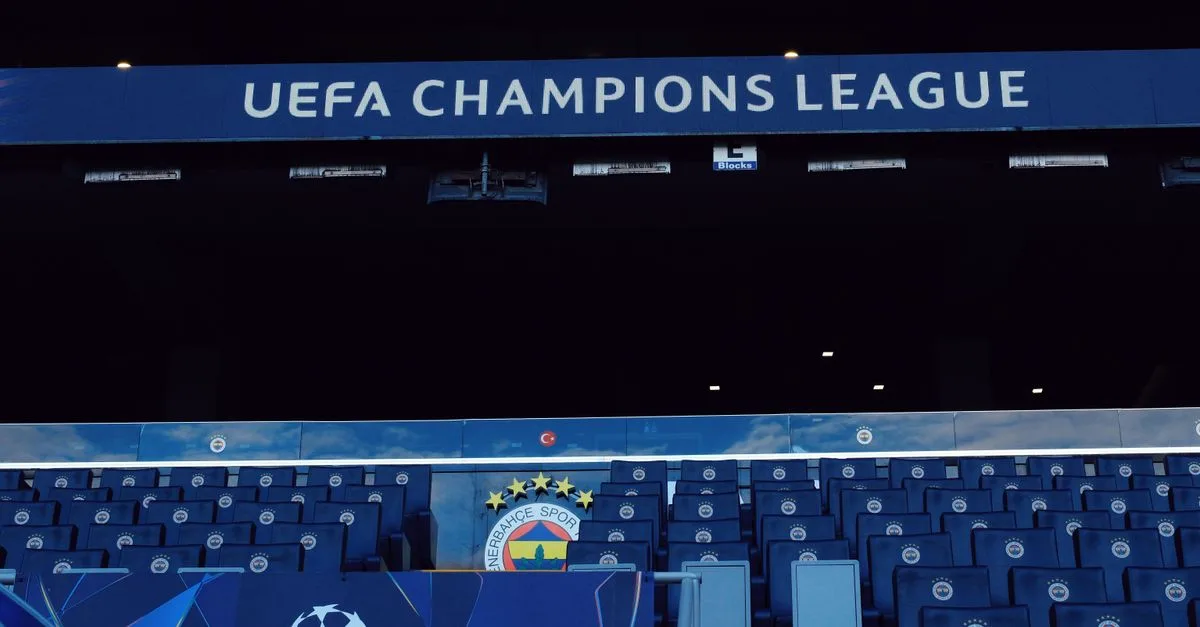 Empty stadium seats under UEFA Champions League signage, showcasing a sports event atmosphere.