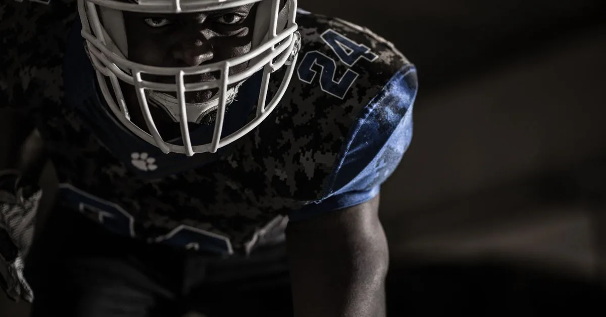 Intense close-up of a focused American football player ready for action on the field.