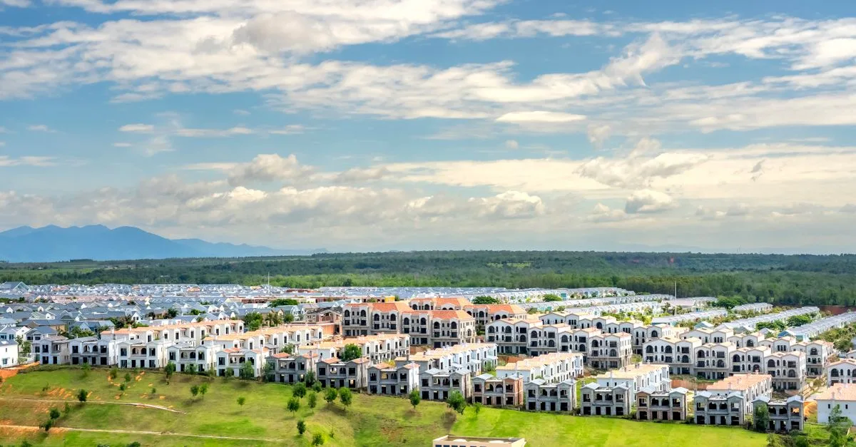 Panoramic aerial snapshot of a suburban residential area with lush greenery under a blue sky.