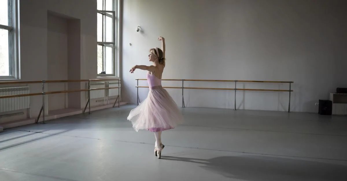 Ballerina performing in an elegant, softly lit dance studio.