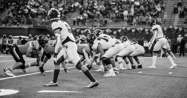 Intense high school football game played in front of spectators, capturing teamwork and energy on the field.