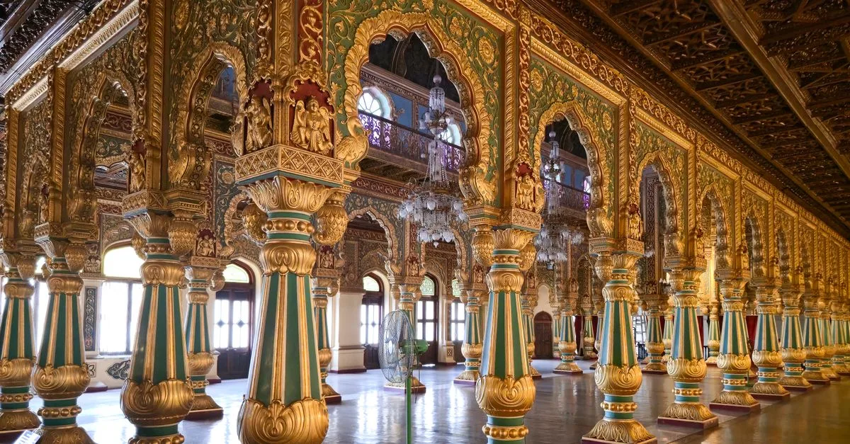 Intricate columns and arches in the opulent hall of Mysore Palace, showcasing detailed Indian architecture.