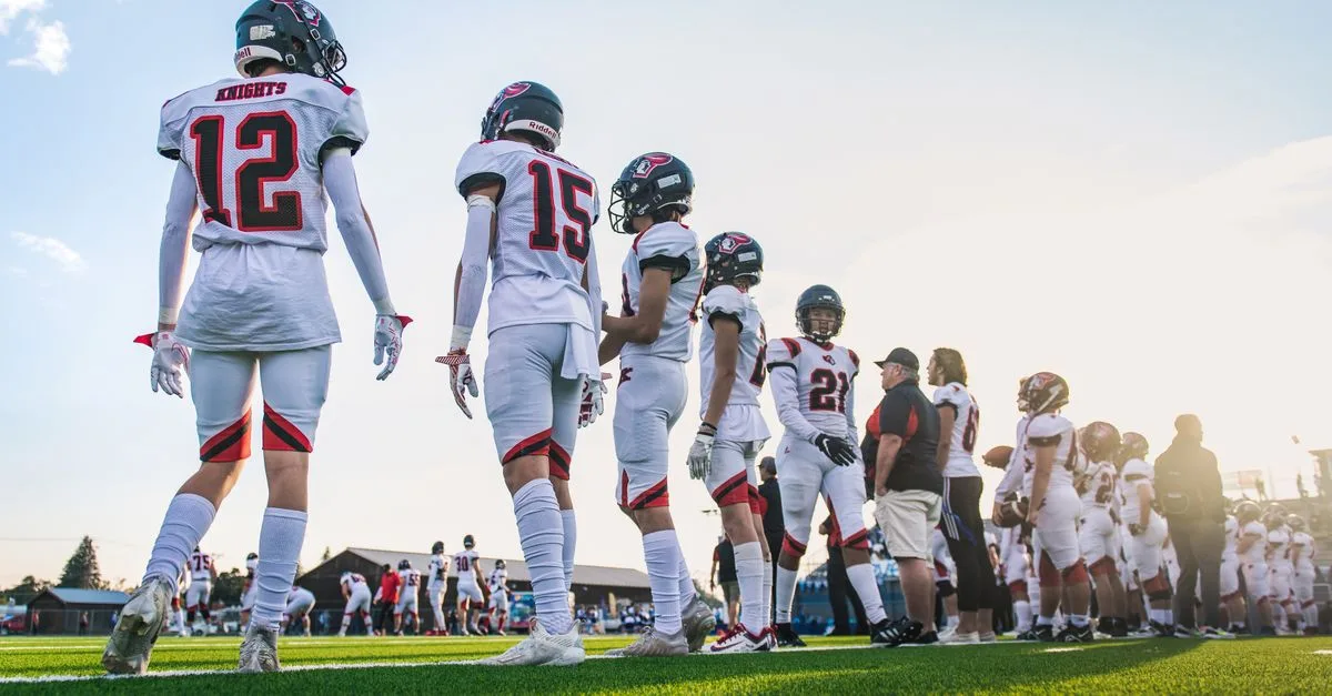 A high school football team lines up on the field, ready for their match.
