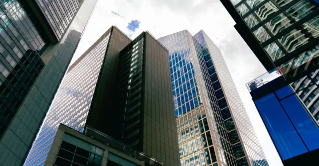 Tall skyscrapers in downtown Frankfurt am Main with a cloudy sky backdrop, showcasing modern architecture.