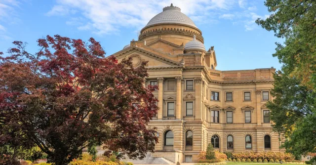 Elegant view of the Luzerne County Courthouse surrounded by autumn foliage under a clear blue sky.