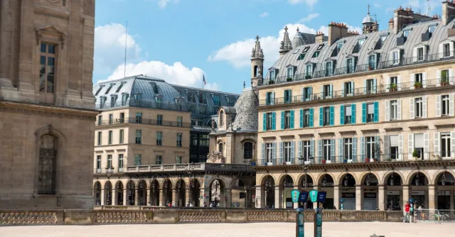 A classic Parisian street view featuring ornate buildings and a clear sky.