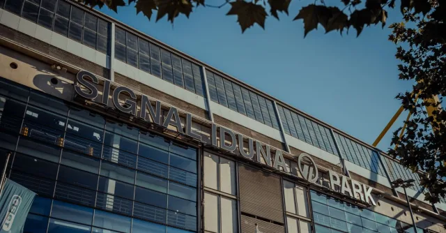 Exterior view of Signal Iduna Park stadium in Dortmund, Germany under clear blue sky.
