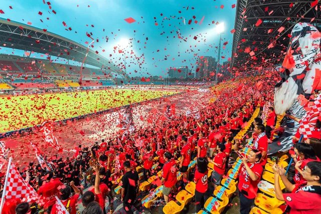 A wide shot of a professional football stadium filled with spectators during a match.
