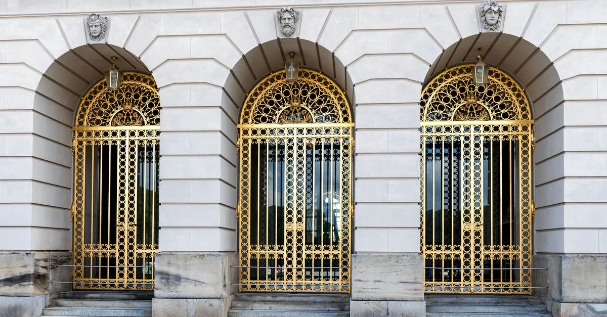 Elegant architectural details of Neues Schloss Herrenchiemsee with golden gates.