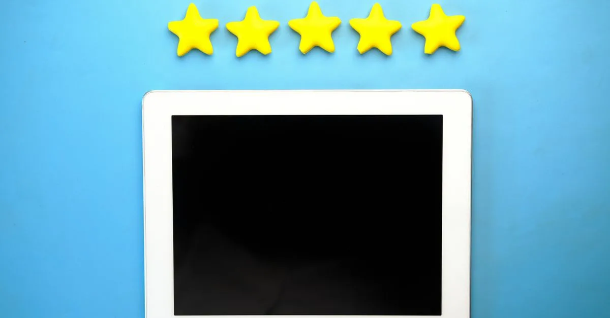 Tablet with five yellow stars on a blue background, ideal for rating concepts.