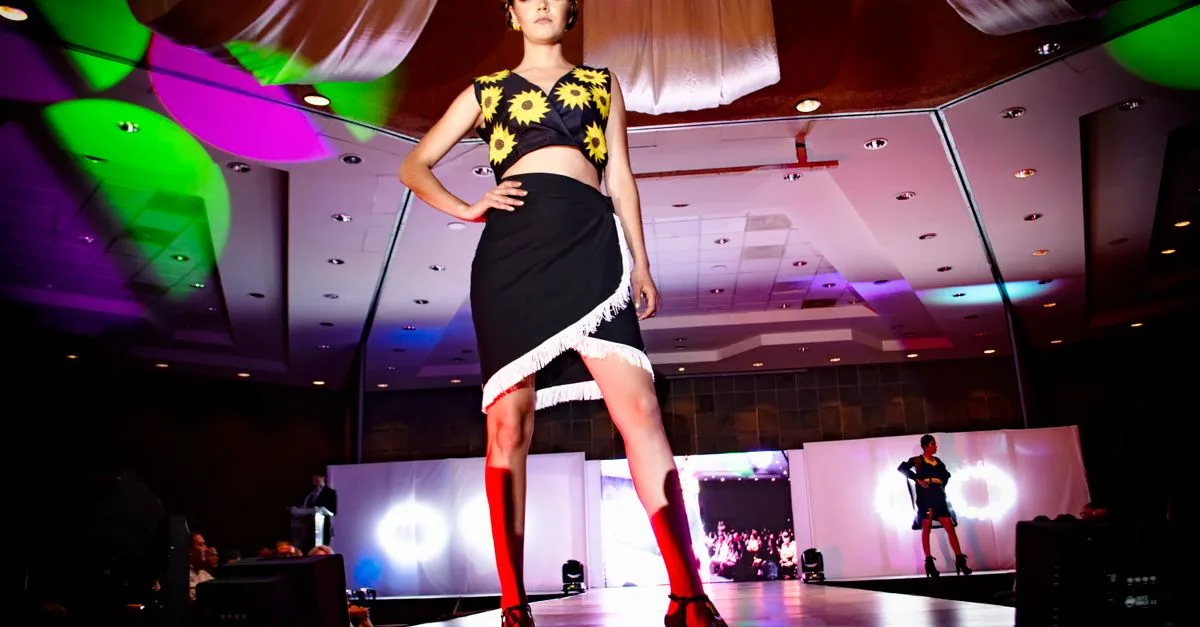 Dynamic fashion model on stage at a vibrant Morelia fashion show.