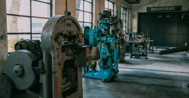 Interior of an old factory showcasing vintage machines and equipment.