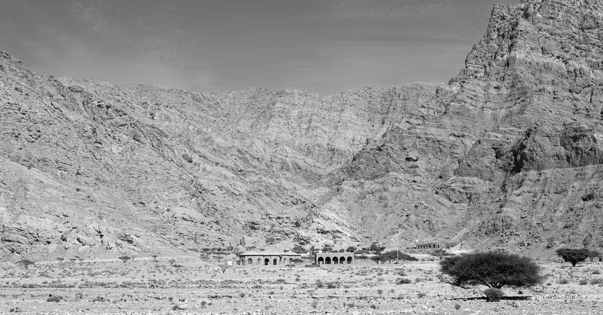 Dramatic black and white photo of a rocky mountain landscape with ancient ruins.