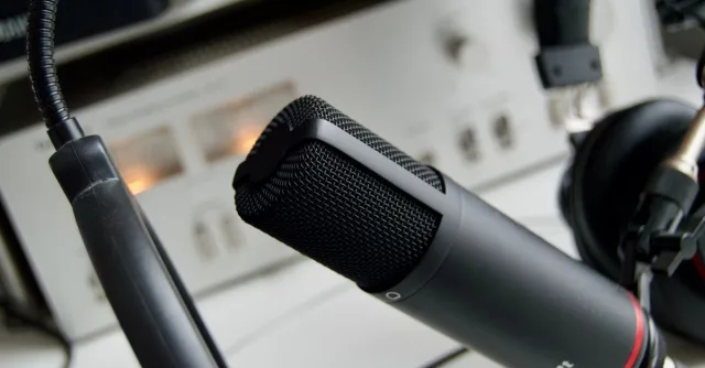Close-up shot of a microphone in a studio setting, ideal for audio recording.