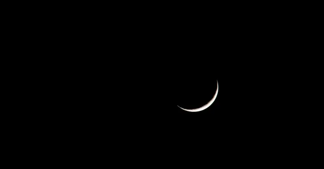 A striking image of a crescent moon set against a deep black sky, showcasing its serene beauty.