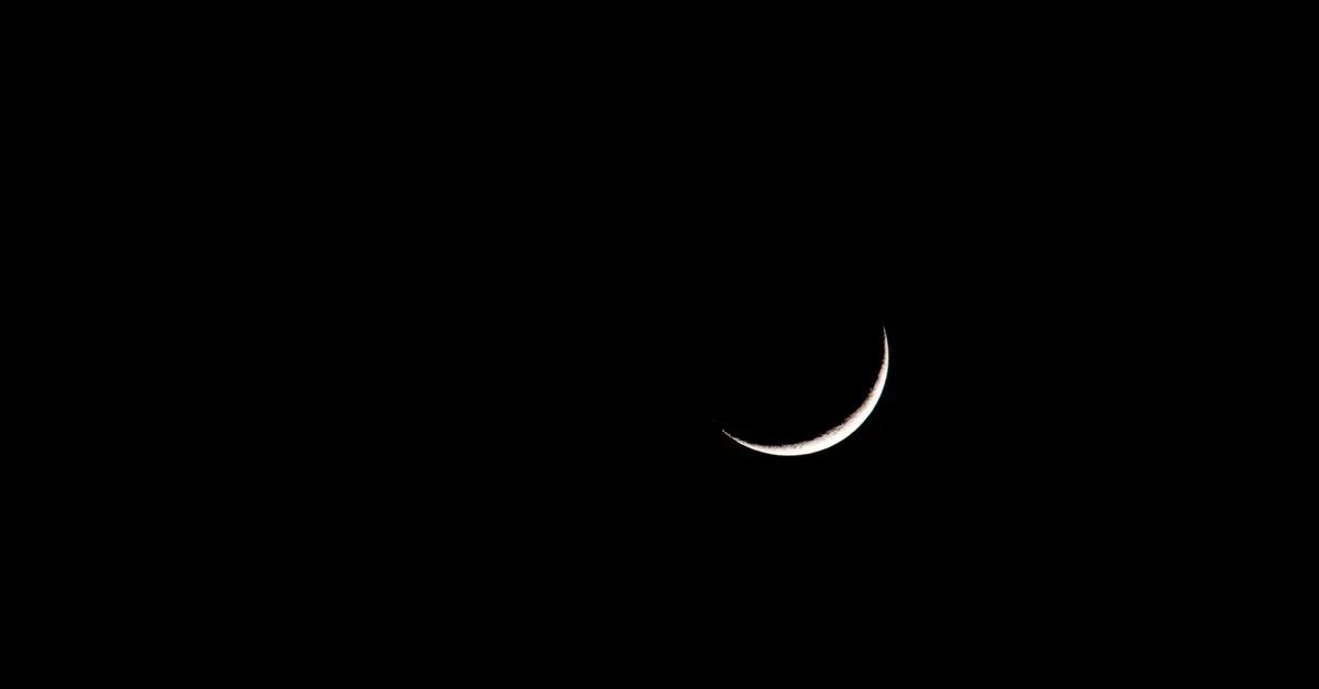 A striking image of a crescent moon set against a deep black sky, showcasing its serene beauty.
