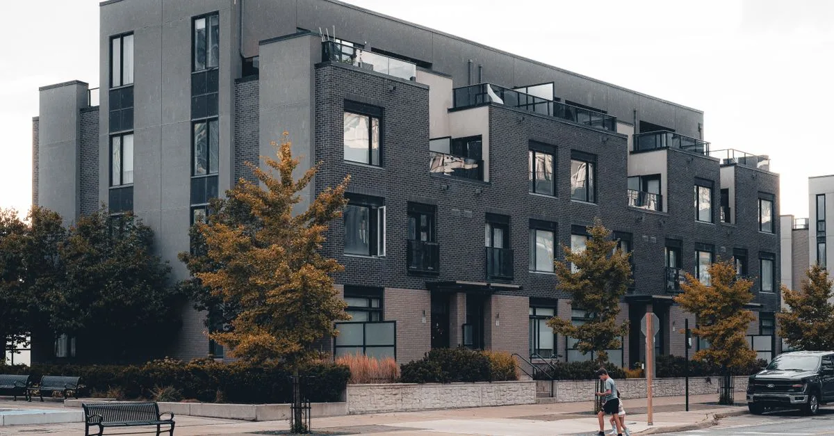 Contemporary urban apartment building with tree-lined street in Mississauga, Ontario.